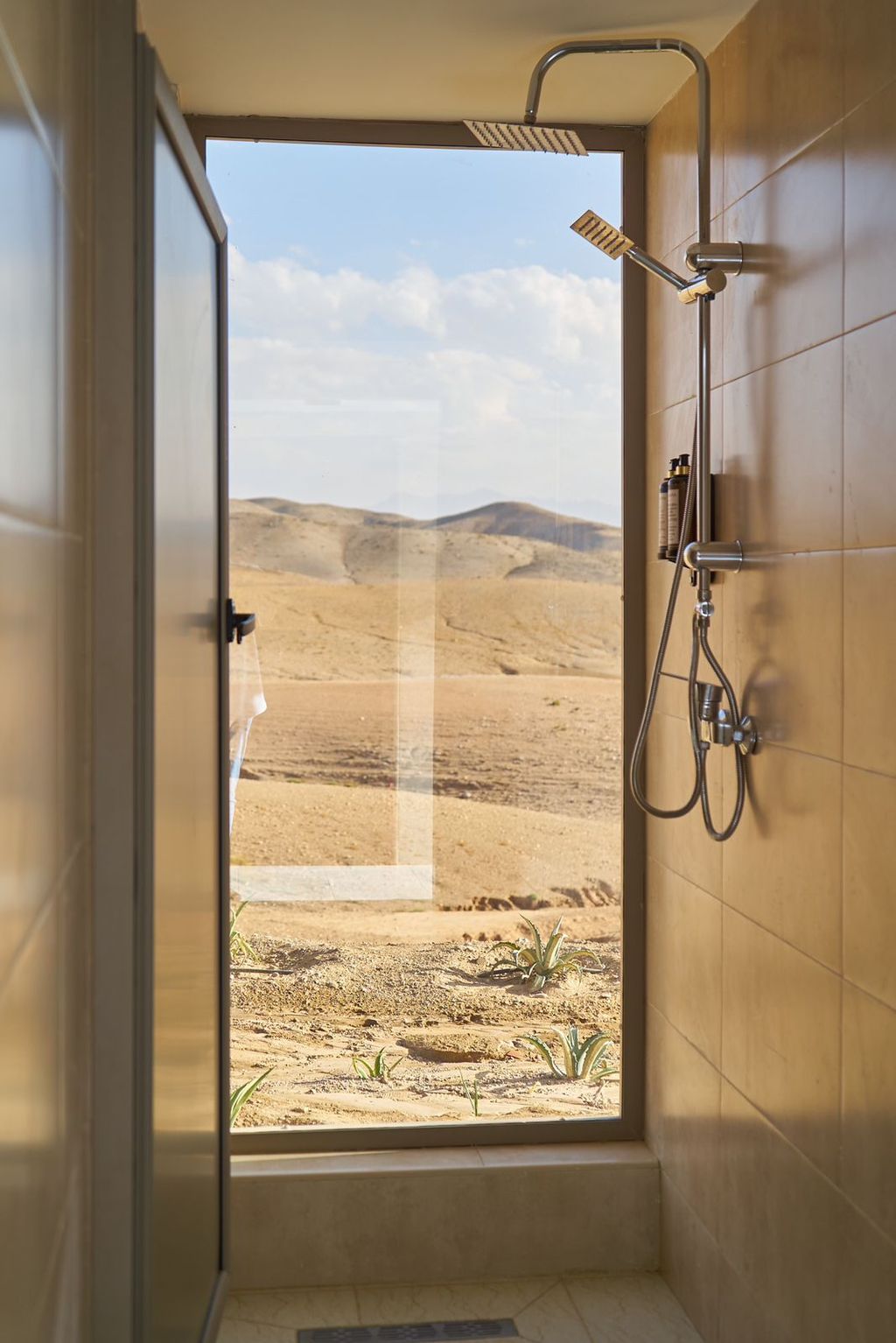 Walk-in shower with a full-height window looking out over the Agafay plateau