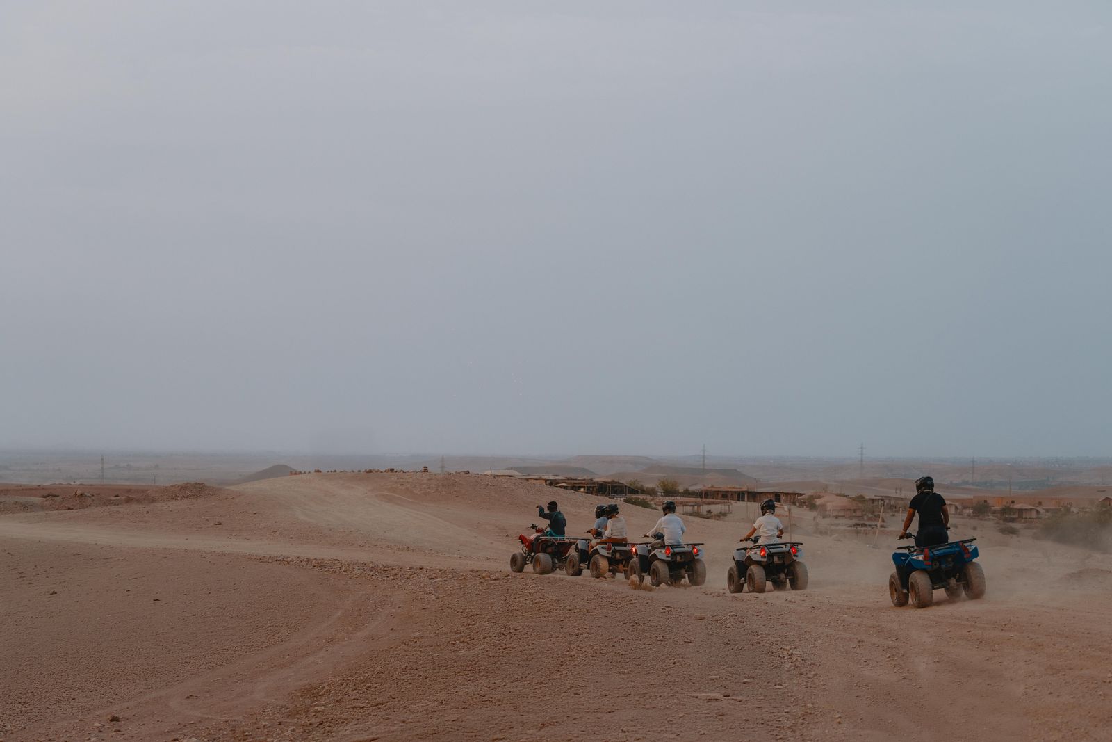 A line of quad bikes heading back towards the camp at dusk on the Agafay plateau